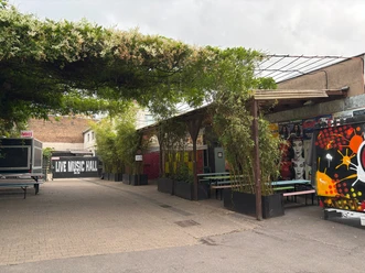 Live Music Hall Outdoor area of the Live Music Hall with colorful graffiti, bamboo plants and seating.