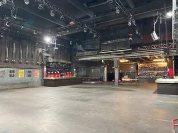 Live Music Hall Die Abbildung zeigt das Innere der Live Music Hall mit leerem Stehbereich und Bühnenbeleuchtung.The picture shows the interior of the Live Music Hall with an empty standing area and stage lighting.