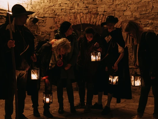 Nachtwächter (3).jpg Eine Gruppe von Personen mit Laternen steht in einem stimmungsvoll beleuchteten, historischen Gewölbe.A group of people with lanterns stand in an atmospherically lit historic vault.Een groep mensen met lantaarns staat in een sfeervol verlicht historisch gewelf.