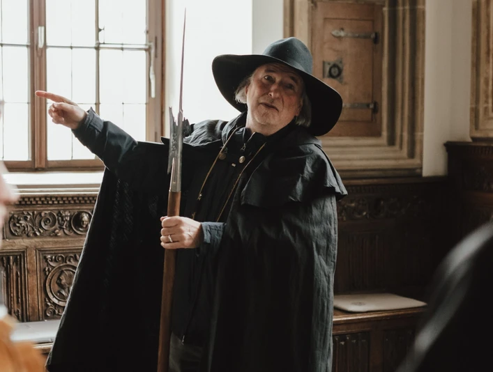 Nachtwächter (Hauptbild).jpg Ein Nachtwächter im historischen Kostüm erklärt Besuchern in einem traditionell eingerichteten Raum Details.A night watchman in historical costume explains details to visitors in a traditionally furnished room.Een nachtwaker in historisch kostuum geeft uitleg aan bezoekers in een traditioneel ingerichte kamer.