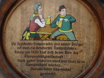 Beschwipster Nachtwächter (3).jpg Holzteller mit gemalten Nachtwächtern im Mittelalter, die Bier an einem rustikalen Tisch genießen.