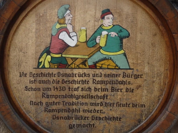 Beschwipster Nachtwächter (3).jpg Wooden plate with painted night watchmen in the Middle Ages enjoying beer at a rustic table.