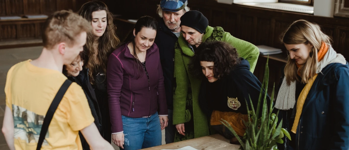 Rathaus- und Altstadt (Hauptbild).jpg A group of interested visitors study an old city map together in a historic building.