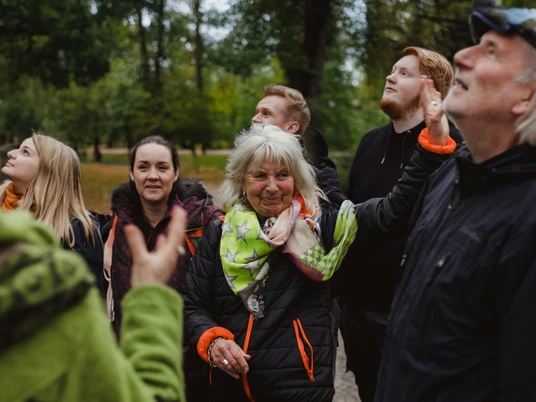 Gertrudenberg (2).jpg Eine Gruppe unterschiedlicher Menschen betrachtet fasziniert etwas in einem bewaldeten Park.A group of different people are fascinated by something in a wooded park.Een groep verschillende mensen is gefascineerd door iets in een bebost park.
