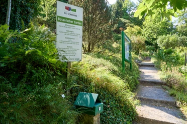 Botanischer Garten Bad Schandau Eingang des Botanischen Gartens Bad Schandau mit Informationsschild neben einem schattigen Weg.