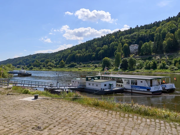 Ferry landing stage in Bad Schandau, surrounded by wooded hills and the calmly flowing river.