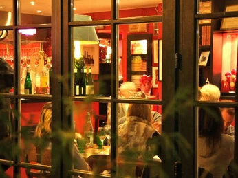 Weihnachtlich1.jpg Ein Blick durch Fenster auf ein festlich beleuchtetes Restaurant mit Gästen am Tisch.A view through the window of a festively lit restaurant with guests at the table.