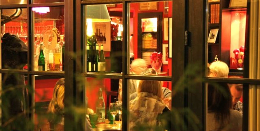 Weihnachtlich1.jpg Ein Blick durch Fenster auf ein festlich beleuchtetes Restaurant mit Gästen am Tisch.A view through the window of a festively lit restaurant with guests at the table.