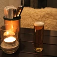 IMG_3073.JPG Kerze und Bierglas auf Holztisch neben Besteckhalter, warmes und gemütliches Ambiente.Candle and beer glass on wooden table next to cutlery holder, warm and cozy ambience.