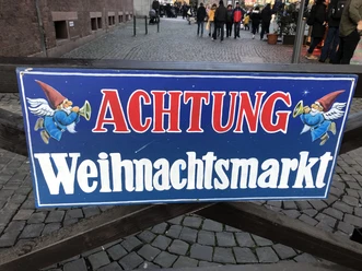 IMG_0578.JPG Warnschild für Weihnachtsmarkt mit zwei kleinen Engeln, die Hörner spielen.