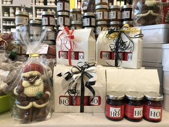 IMG_1281.jpeg Geschenkverpackungen und Schokoladenweihnachtsmann vor Konfitürengläsern auf einem Ladentisch.Gift wrapping and chocolate Santa Claus in front of jam jars on a store counter.