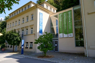 Museum Bad Schandau Gelbes Gebäude mit grünen Bannern.