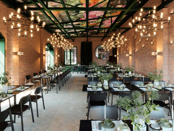 Evenementenschuur Ranunkelhof Hoge eetzaal, een voormalige schuur met veel tafels en stoelen, stijlvol ingericht met bloemen en kroonluchterachtige verlichting aan de muur