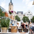 JenaerTöpfermarkt©JenaKultur_CWorsch+(104).jpg Im Vordergrund stehen Töpferwaren des Jenaer Töpfermarktes und im Hintergrund bewegen sich viele Menschen.