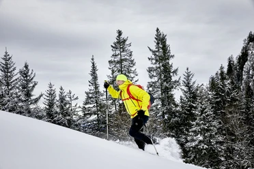 Ein Mann läuft mit den Schneeschuhen einen Hang hoch auf der Klewenalp