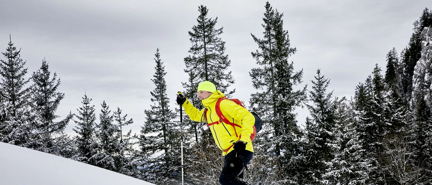 Ein Mann läuft mit den Schneeschuhen einen Hang hoch auf der Klewenalp
