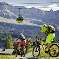 Lu_Tourismus_Klewen_BB_5.9.22_14.jpg Ein Mann und eine Frau biken unterhalb der Gondelbahn Stockhütte