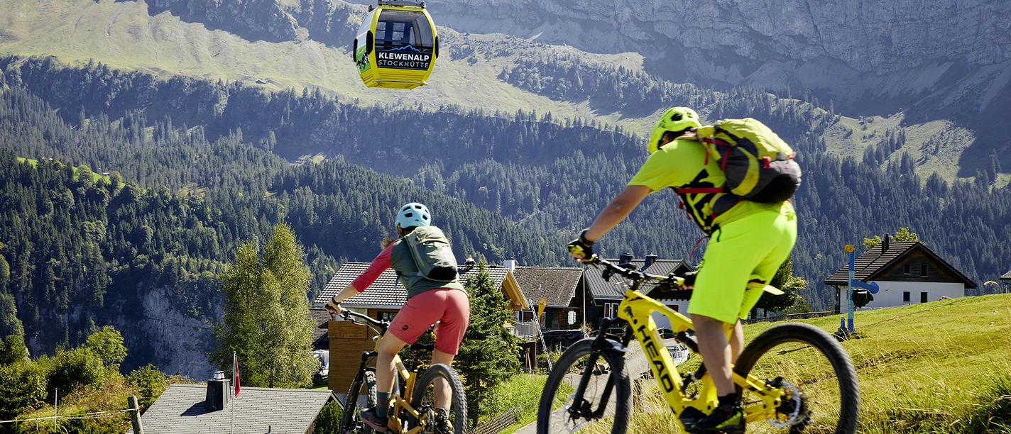 Lu_Tourismus_Klewen_BB_5.9.22_14.jpg Ein Mann und eine Frau biken unterhalb der Gondelbahn Stockhütte