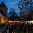 Adventsmarkt Thallwitz OT Nischwitz - Weihnachten in der Region Leipzig Menschen genießen den abendlichen Adventsmarkt vor der beleuchteten Kirche Nischwitz.