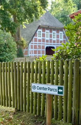 wanderweg-center-parcs-bispingen (1).jpg Ein ruhiger Weg durch grüne Natur führt zu einem traditionellen Fachwerkhaus in Bispingen.