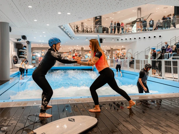 Surfcoach mit Surfschülerin an der Hasewelle