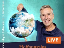 Dirk Steffens hält eine Weltkugel, lächelnd vor türkisblauem Hintergrund, mit Schriftzug "Live".