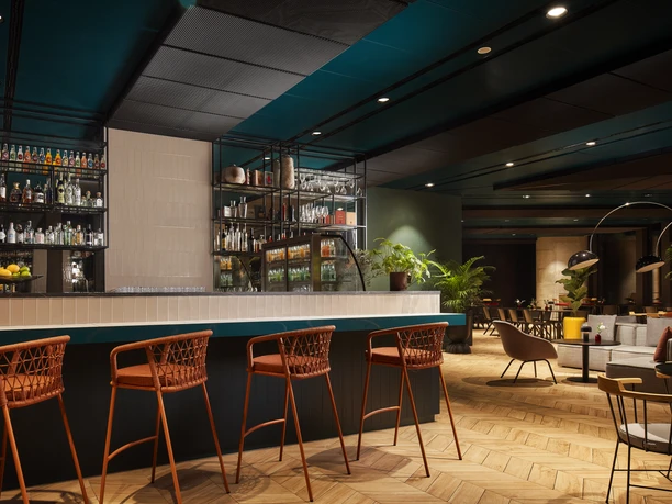 Oaks Bar NH Collection Frankfurt Spin Tower Bar counter with orange stools, warm interior lighting