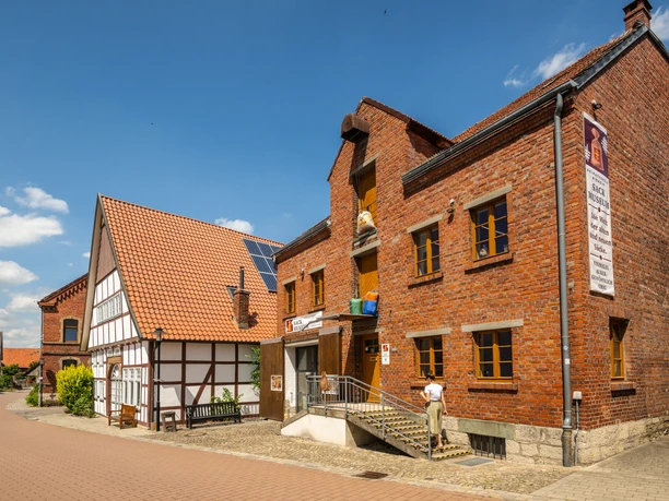 Nieheim-Sackmuseum-Teutoburger-Wald-Stadt-Nieheim-D-Ketz-205.jpg Backsteinbau des Sackmuseums in Nieheim mit Eingangstreppe und Fachwerkhaus daneben bei Sonnenschein.