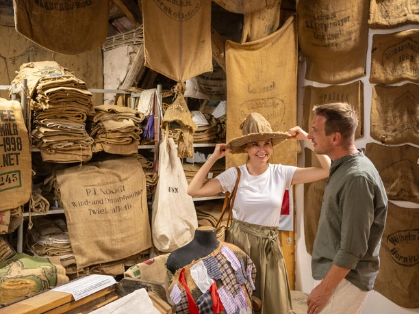Nieheim-Sackmuseum-Teutoburger-Wald-Stadt-Nieheim-D-Ketz-213.jpg Zwei Personen betrachten Säcke im Sackmuseum, eine Frau trägt einen Hut aus grobem Sackleinen.