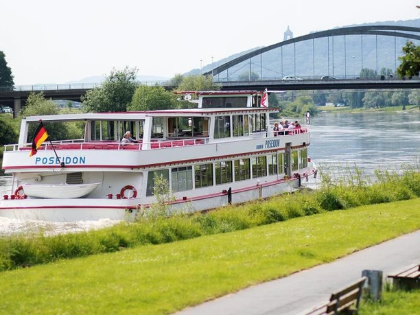 Zu sehen ist das Schiff Poseidon auf der Weser. Im Hintergrund sieht man die Weserbrücke und das Kaiser-Wilhelm Denkmal.