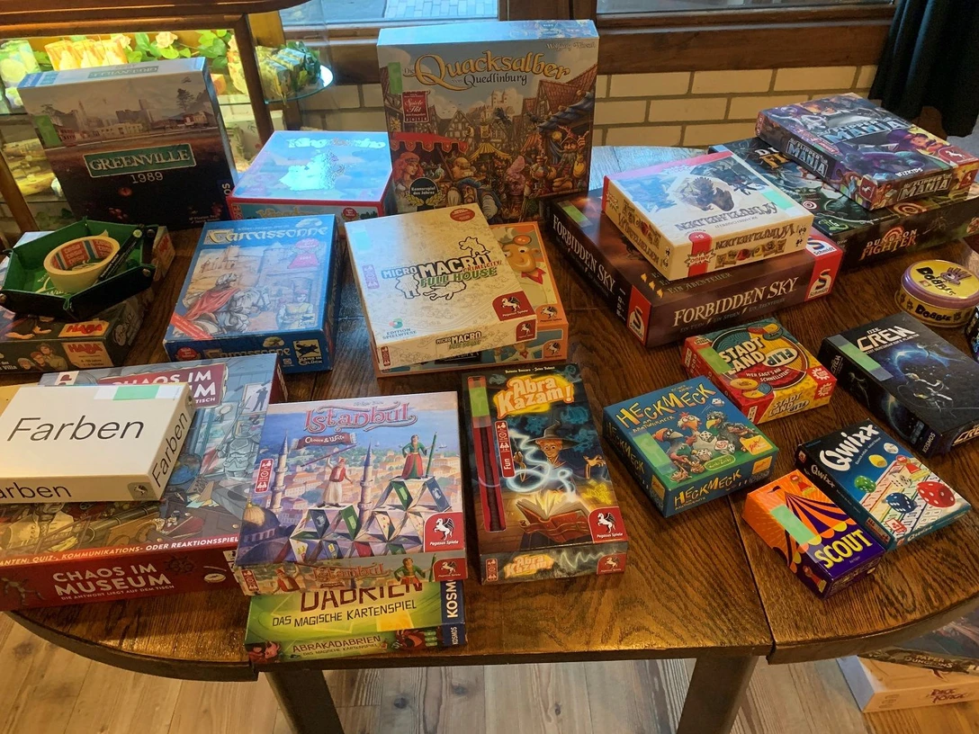 Spieletisch Taubenhof Verschiedene Gesellschaftsspiele auf Holztisch laden im Taubenhof zu gemeinsamen Spielrunden ein.
