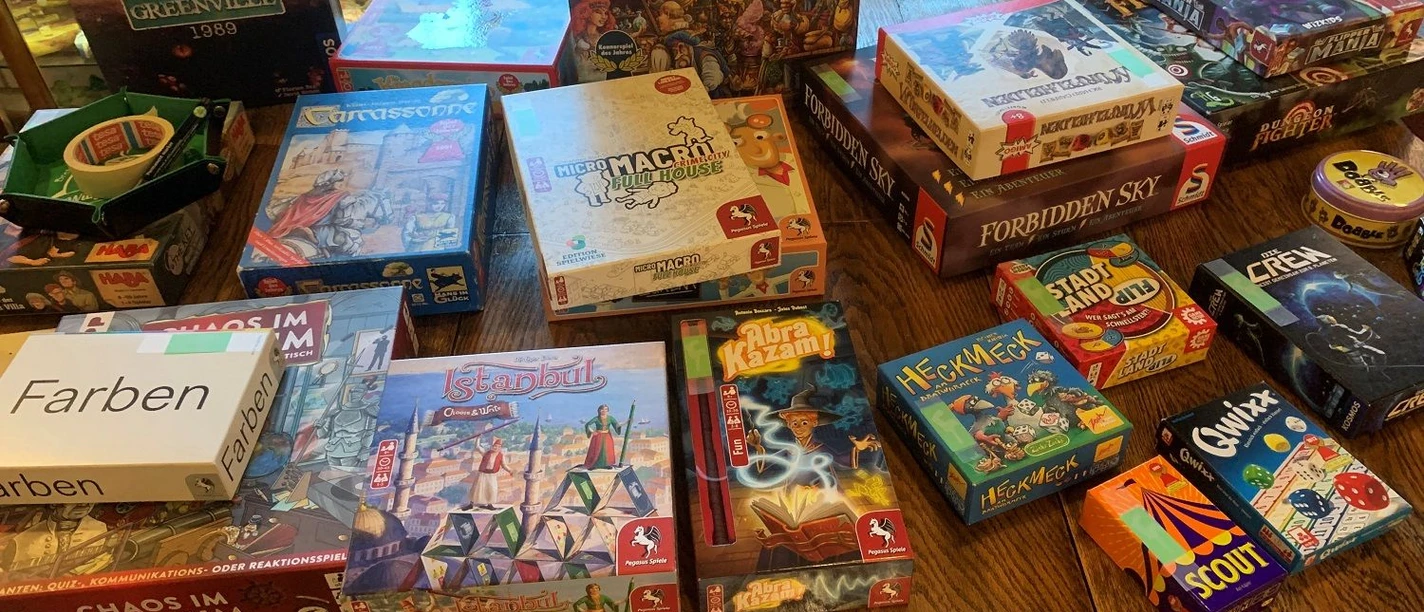 Spieletisch Taubenhof Verschiedene Gesellschaftsspiele auf Holztisch laden im Taubenhof zu gemeinsamen Spielrunden ein.