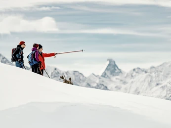 Guided ridge tour with panoramic break Teilnehmer einer Schneeschuhtour Aletsch Grattour verweilen mit Blick zum Matterhorn und diskutieren die Route am WintergratParticipants on a snowshoe tour Aletsch ridge tour linger with a view of the Matterhorn and discuss the route on the winter ridgeLes participants à une randonnée en raquettes sur l'arête d'Aletsch s'attardent avec vue sur le Cervin et discutent de l'itinéraire sur l'arête hivernale.