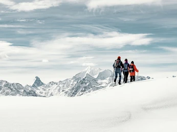 Snowshoe tour with a view of the Matterhorn Wanderer auf Schneeschuhtour Aletsch Grattour mit Blick auf das Matterhorn und die umliegenden Walliser Alpen im WinterHikers on a snowshoe tour Aletsch ridge tour with views of the Matterhorn and the surrounding Valais Alps in winterRandonneurs en raquettes à neige Aletsch Grattour avec vue sur le Cervin et les Alpes valaisannes environnantes en hiver