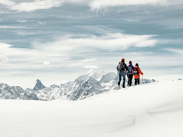 Snowshoe tour with a view of the Matterhorn Hikers on a snowshoe tour Aletsch ridge tour with views of the Matterhorn and the surrounding Valais Alps in winter
