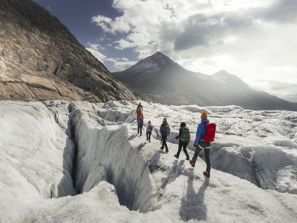 Seilschaft auf dem Aletschgletscher Teilnehmer der Gletschertour Jungfraujoch Aletsch überqueren gesichert eine tiefe Eisspalte auf dem Grossen Aletschgletscher