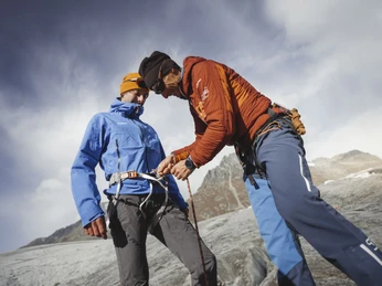 Contrôle de l'équipement avant le début du tour Guide überprüft bei Gletschertour Jungfraujoch Aletsch die Ausrüstung eines Teilnehmers direkt auf dem GletscherfeldGuide checks a participant's equipment directly on the glacier field during the Jungfraujoch Aletsch glacier tourLe guide vérifie l'équipement d'un participant directement sur le glacier lors de la randonnée sur le Jungfraujoch Aletsch.