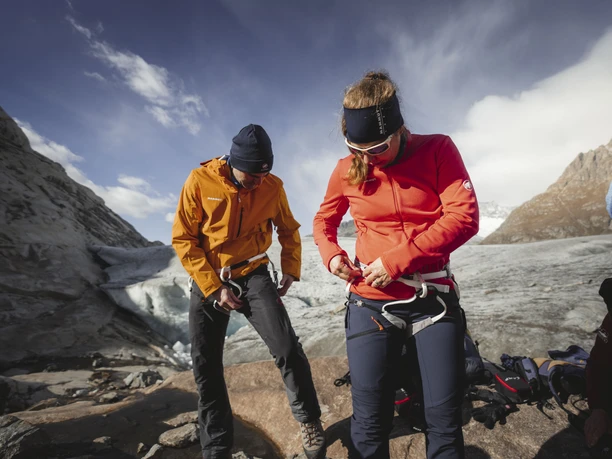 Preparation for the glacier tour Participants on the Aletsch Glacier round tour put on their safety equipment at the edge of the glacier before climbing onto the ice
