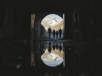 Exit through the Tälligrat Tunnel Teilnehmer der Aletschgletscher Rundtour verlassen den Tälligrattunnel mit Blick auf verschneite Berge und FelsenParticipants on the Aletsch Glacier round tour leave the Tälligrat Tunnel with a view of snow-covered mountains and rocksLes participants au circuit du glacier d'Aletsch quittent le tunnel du Tälligrat avec vue sur les montagnes et les rochers enneigés.