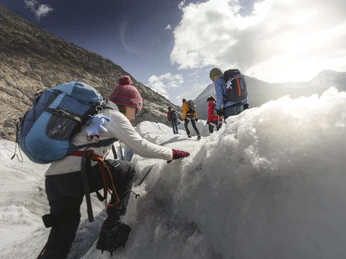 Aufstieg über das Eisfeld Gruppe der UNESCO Gletschertour Aletsch steigt über zerklüftete Eisflächen des Aletschgletschers mit SeilsicherungGroup on the UNESCO Aletsch Glacier Tour climbs over the rugged ice surfaces of the Aletsch Glacier with rope protectionLe groupe du Tour du Glacier d'Aletsch de l'UNESCO s'élève sur les surfaces de glace déchiquetées du glacier d'Aletsch avec une corde de sécurité.