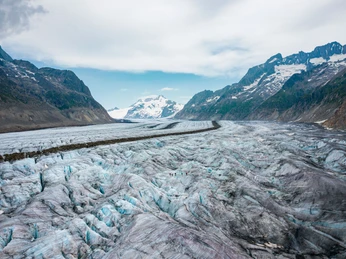 Luftaufnahme Aletschgletscher bei Märjelensee Drohnenaufnahme des Aletschgletschers mit Moränen und Wandergruppen während der Gletschertour Jungfraujoch MärjelenseeDrone image of the Aletsch Glacier with moraines and hiking groups during the Jungfraujoch Märjelensee glacier tourVue par drone du glacier d'Aletsch avec des moraines et des groupes de randonneurs pendant le tour du glacier Jungfraujoch Märjelensee