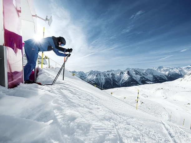 Skier at the start of the speed course Skier in racing position starts on the Fiescheralp speed course during the Glacier Challenge Skiline Aletsch Arena