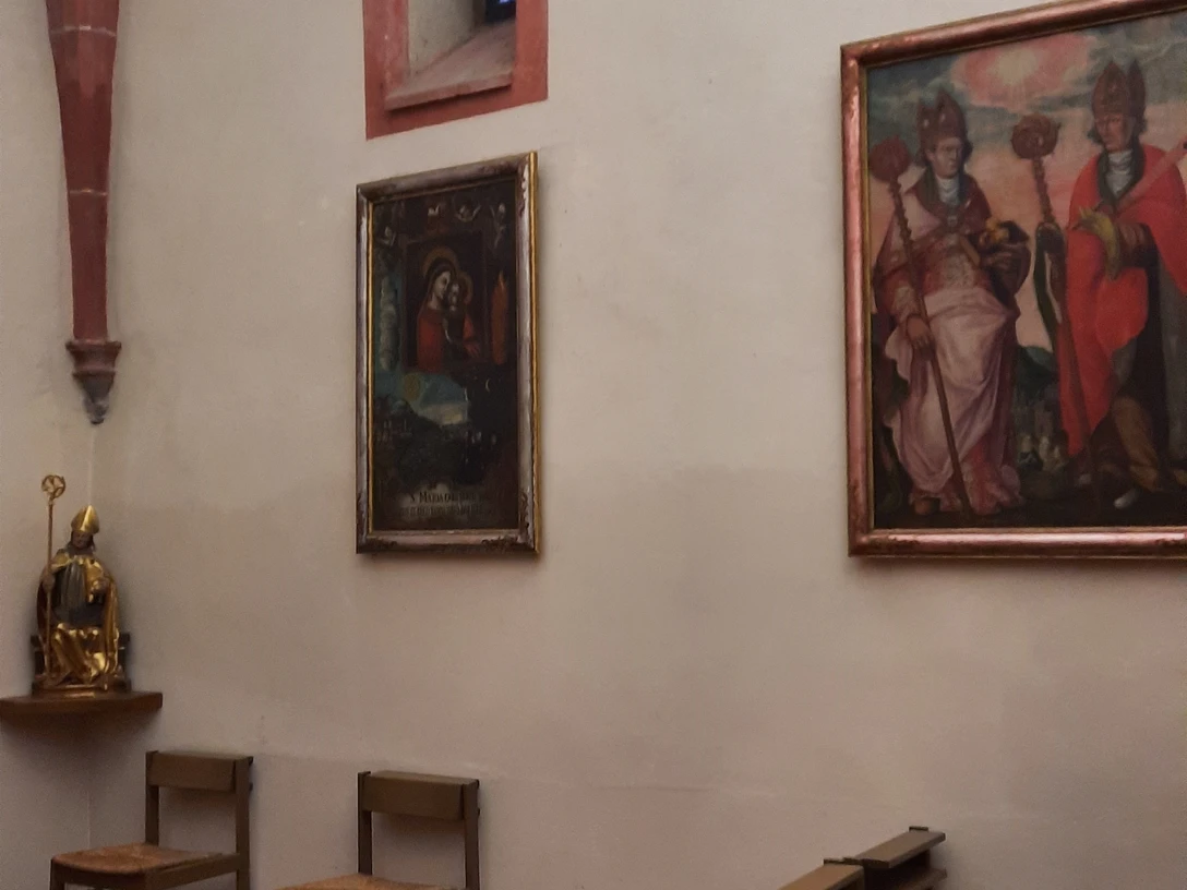 Blick auf zwei Stuhlreihen und Wandbilder im Klauskirchl