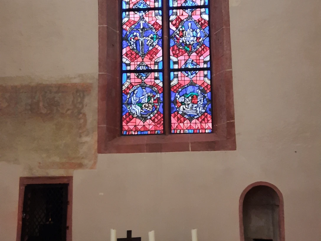 Blick auf den Altar und das bunte Kirchenfenster im Klauskirchl
