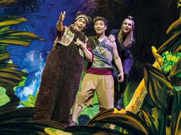 Dschungelbuch - das Musical.jpg >Das Bild zeigt ein Bühnenbild aus dem Musical Dschungelbuch. Es zeigt Mogli, Balu und ein Mädchen