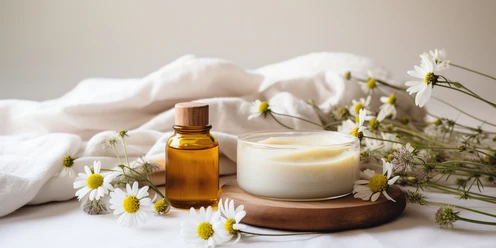 © Adobe Stock Self care card with organic cream, natural oil, aroma sticks, sleeping mask and wild flowers on white background.