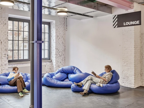 Schirn Dondorf Druckerei Lounge mit blauen Sitzsäcken, zwei Leser*innen, industrielles Ambiente