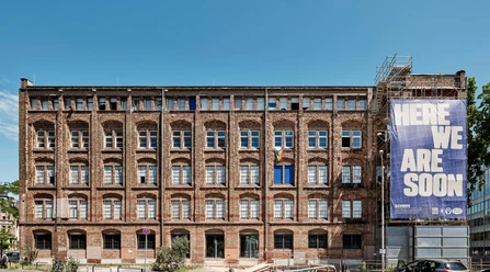 Schirn Dondorf Druckerei Brick factory with scaffolding and "HERE WE ARE SOON" banner in Frankfurt