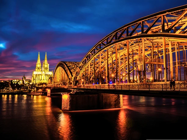 RikoloniaDomTeamlicht.png Hell erleuchtete Hohenzollernbrücke und Kölner Dom bei Nacht.