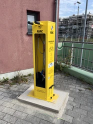 Radservice-Station Overath Gelbe Radservicestation vom ADAC mit Werkzeugen und Fahrradpumpe, nahe Bahngleisen.